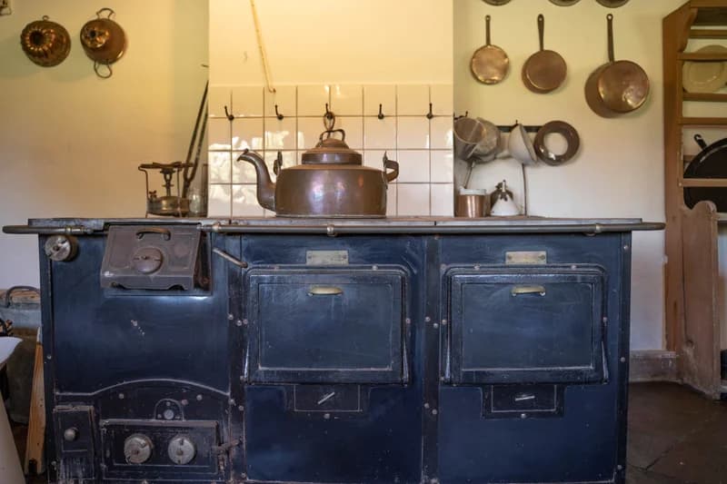 Historisk køkken med kobberpander og ovn