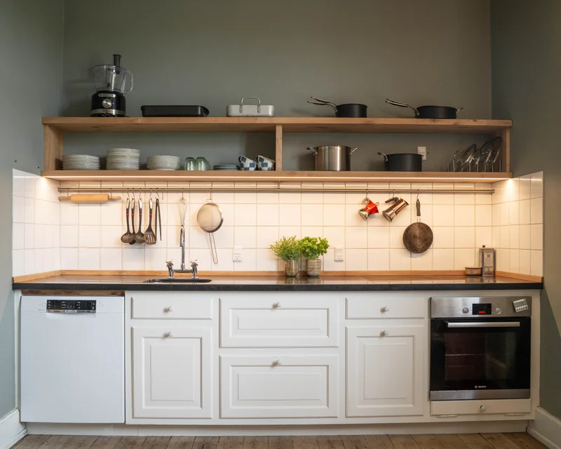 Moderne køkken med hvide skabe og egehylder