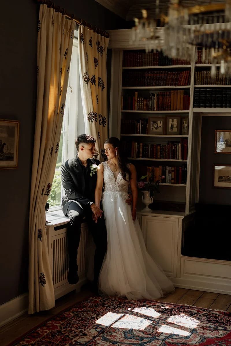 Brudepar ved vinduet i biblioteket
