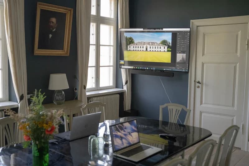 Møderum med forfaderportræt og blågrønt interiør